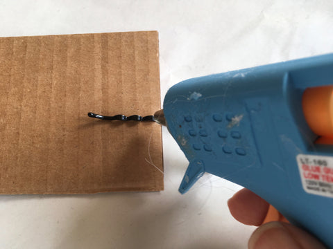 Photo showing applying hot glue to bobby pin