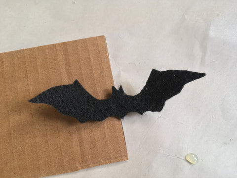 Photo of felt bat and bobby pin attached to cardboard for assembly