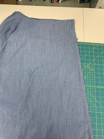 Right sides together center front seam of long skirt is pinned on a green cutting mat.