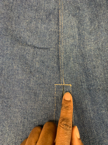 reinforced stitching on the top of the slit on the right side of the denim skit.