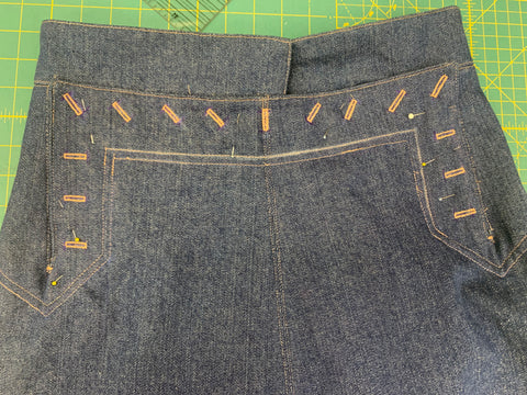 buttonholes made on the front bib of the denim skirt