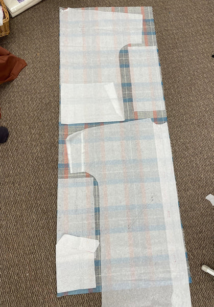 Basics Overcoat pattern pieces laid out on the plaid fabric.
