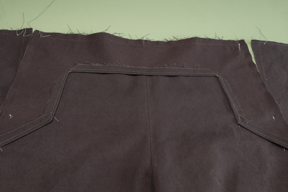 The top of the Front Buttonhole facing sewn to the top of the pant.