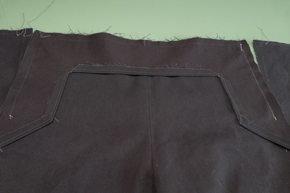 the top and both sides of the Buttonhole Facing sewn to the pant front.