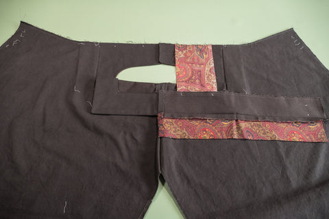 Pocket bag sewn to top of pant and on the bottom edge of the waistband.