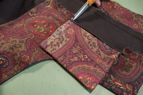 The seam allowance is press upward, clipping at the pocket edges allows the pocket to hang down properly.