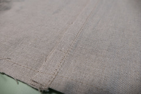 The wrong side of the sleeve edge stitched with the seam pressed to the back.