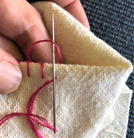 blanket stitch, step 2, red thread on white fabric