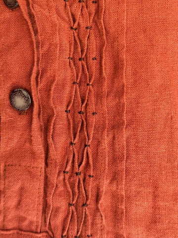 close up of pintucks on a burnt orange croatian shirt dress