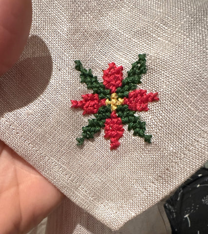 Poinsettia embroidery on grey linen napkin.