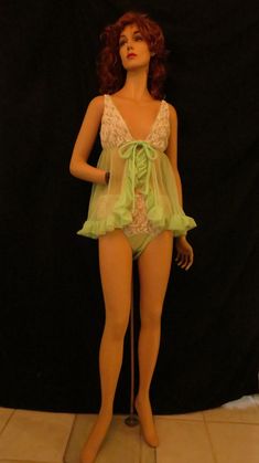 Mannequin wearing a babydoll lingerie dress with lime green sheer skirt and white lace bodice.