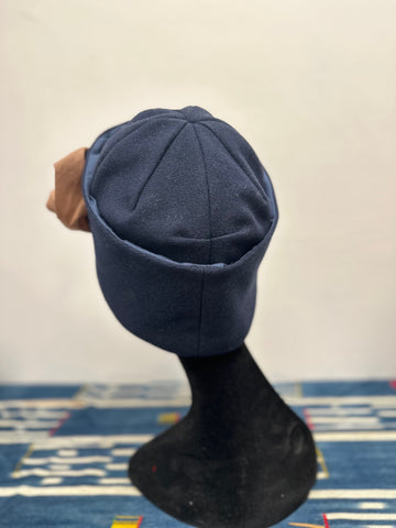Navy wool cloche on a black hat form, from behind.