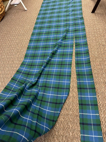 blue and green tartan fabric on a brown carpeted floor