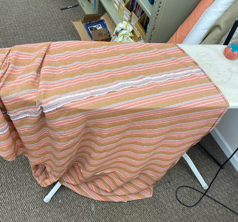 Image of the dress on an ironing board with the seam facing up.