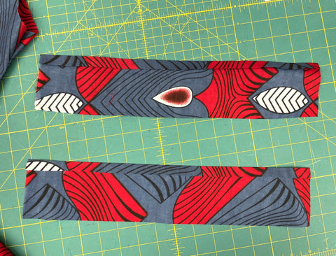 two strips of fabric for cuffs on a green cutting mat