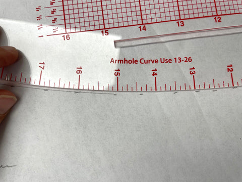 Clear plastic curved ruler on a white pattern piece.