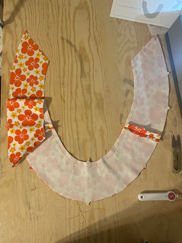 Stay stitching on yoke pieces of a dress.  Fabric is orange floral.