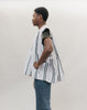side view of Young African American man standing in front of a white studio backdrop wearing the men's Ghanaian Smock