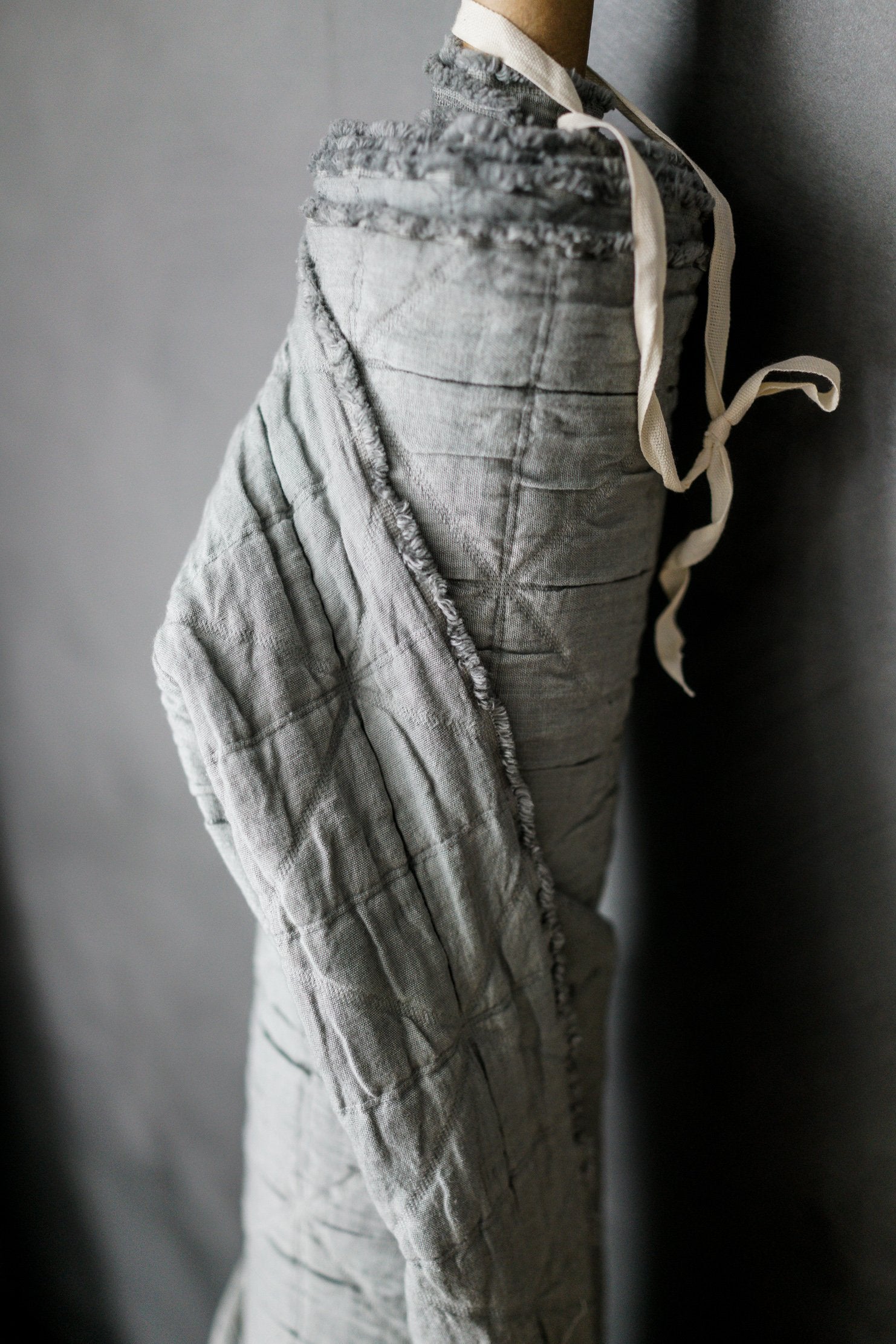 A quilted cotton fabric in a light grey color