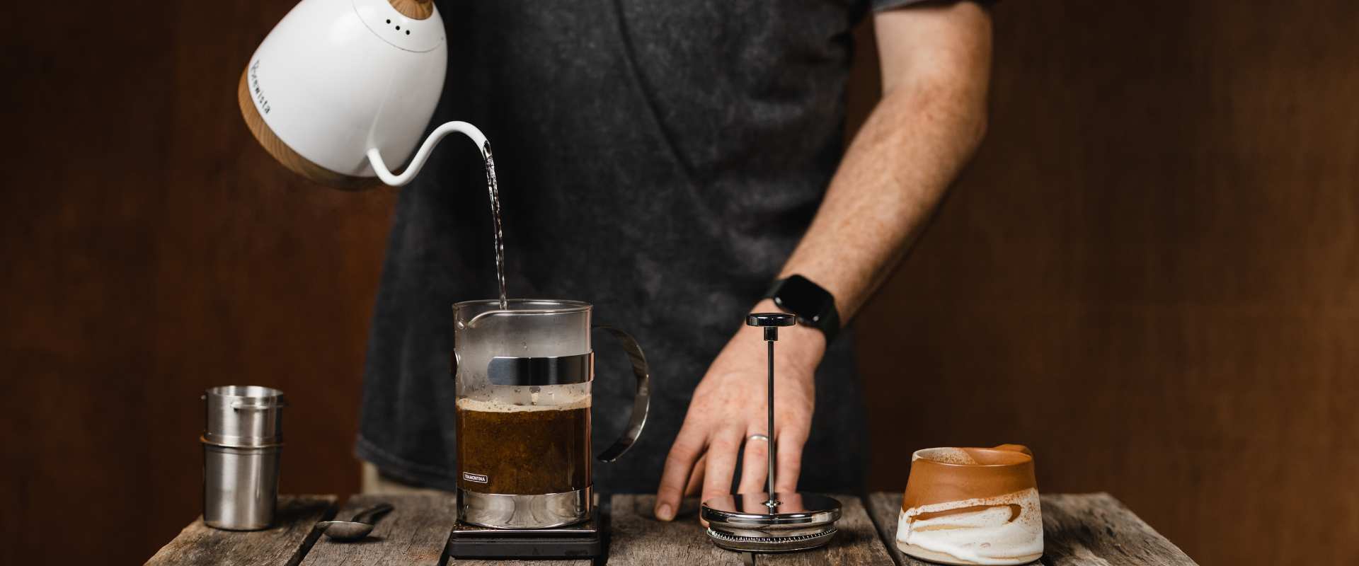 person pouring hot water into plunger