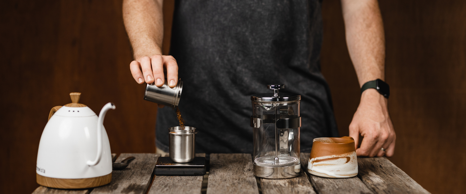 person pouring grinds into plunger 