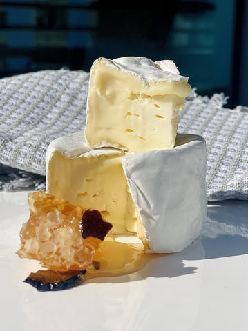 cut wheel of Marin French Cheese Petite Camembert with truffle honey