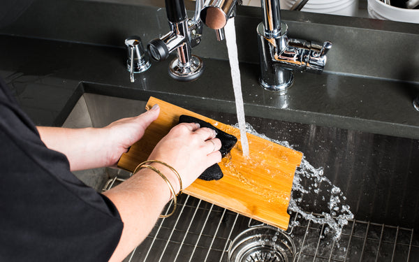 washing a bamboo board with hot water and soap