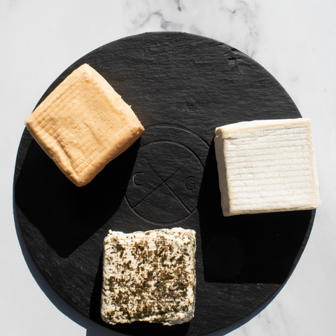 round slate serving board with cheese