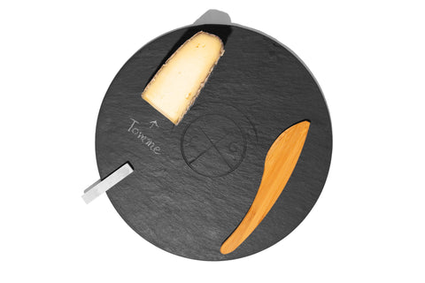 circular slate serving board with cheese, bamboo knife, and soapstone chalk