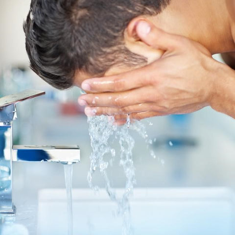 person washing face with facial cleanser