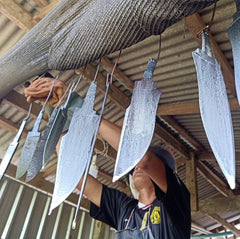 Knife maker hanging salt bath heat treated knife blanks in Thailand