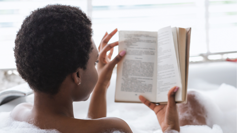 Woman reading a book in a bubble bath