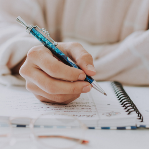 Woman holding pen and writing in her planner