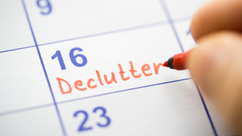 Hand writing the word declutter on a calendar