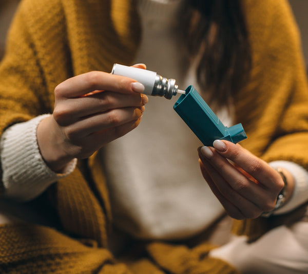 asthmatic woman with inhaler in hands