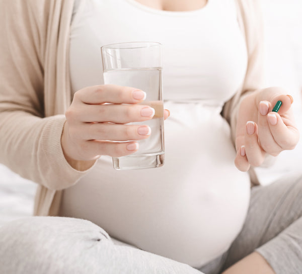 pregnant woman holds iron supplements