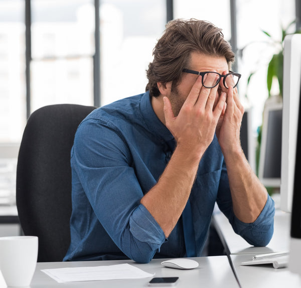 man with signs of chronic stress at his desk