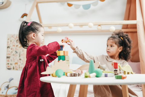 Two children playing with building blocks. 