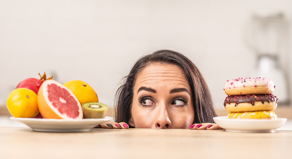 Women trying to choose between healthy fruits or donuts