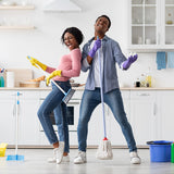 woman and man dance around while cleaning the kitchen 