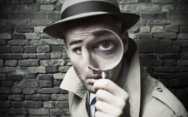 vintage detective holding up a magnifying glass to get a closer look