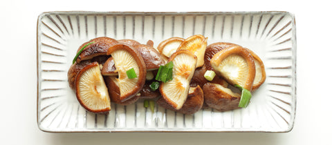 Pan-fried Shiitake mushrooms served on a rectangular plate