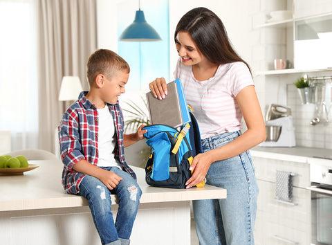 Mom and son unpack his school backpack and talk about his day.