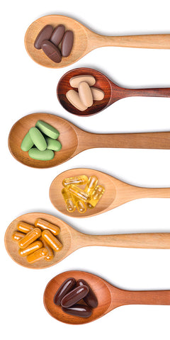 different kinds of vitamins/supplements lined up on wooden spoons