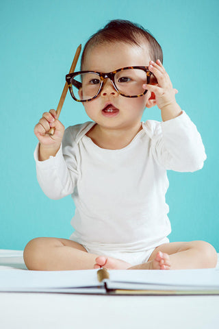 cute baby wearing adult glasses looking smart