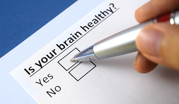 close up of hand holding pen checking off box to question: "Is your brain healthy? Yes or No"