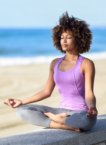 Woman meditates at the beach