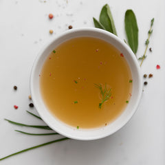 Bowl of broth with herbs