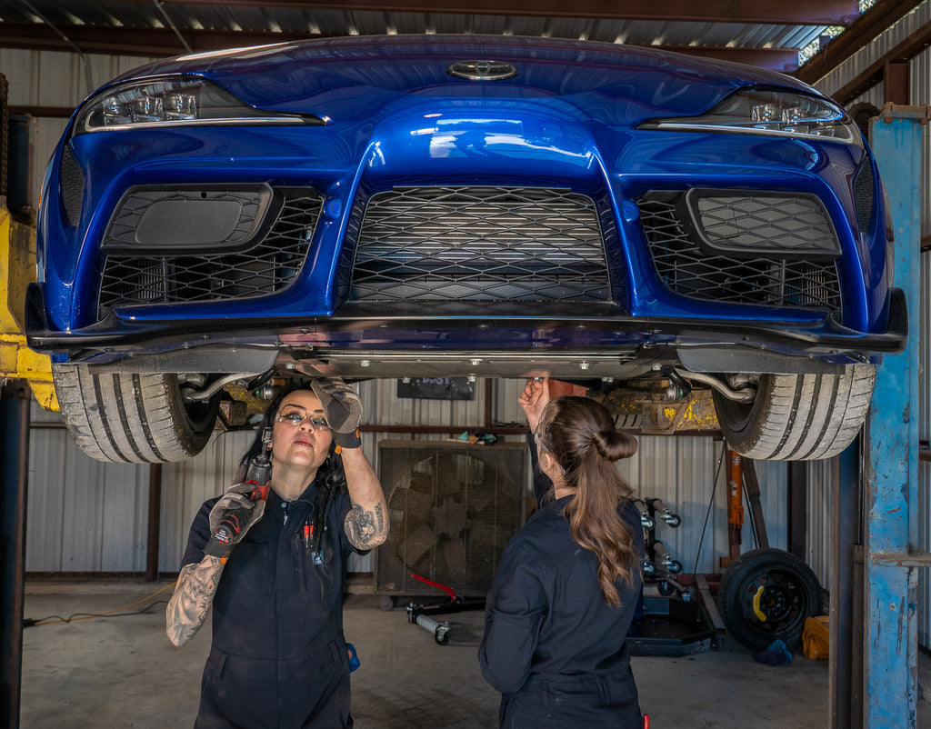 Faye works underneath a 2023 Toyota