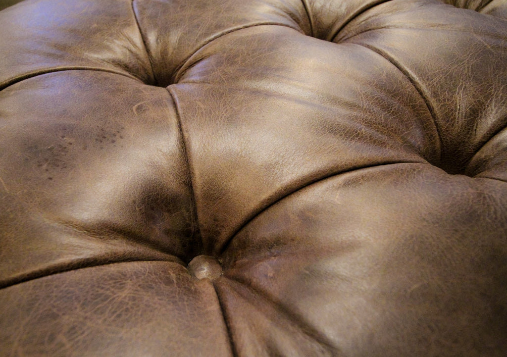 Hand tufted diamond button tufting on top of leather ottoman